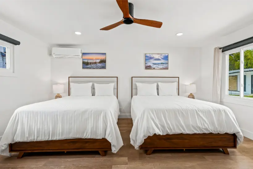 Bedroom setup featuring two identical queen beds with white linens.