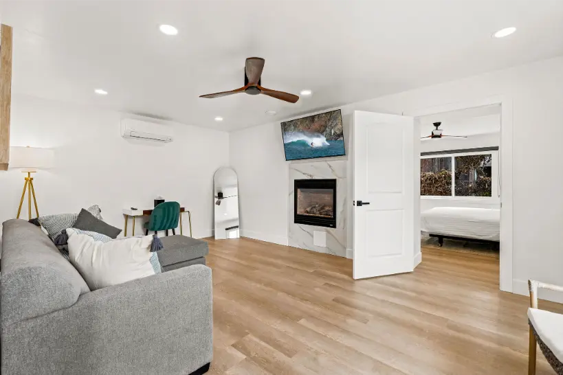Bright living area with a fireplace and open door to the bedroom.