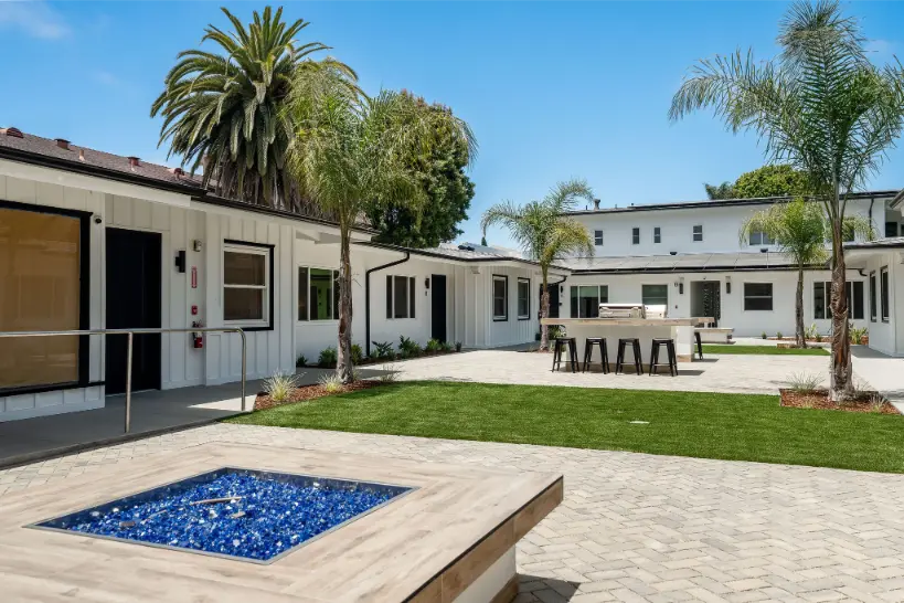 Courtyard corner with palm trees and a paved walkway.