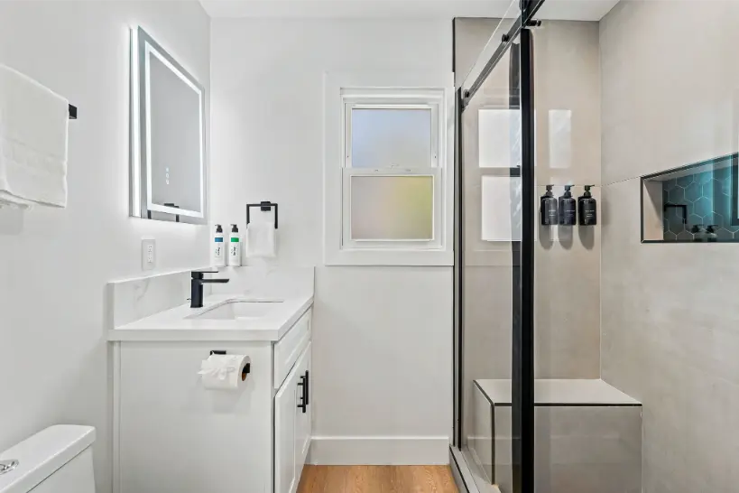 Modern bathroom featuring a glass walk-in shower and white vanity.