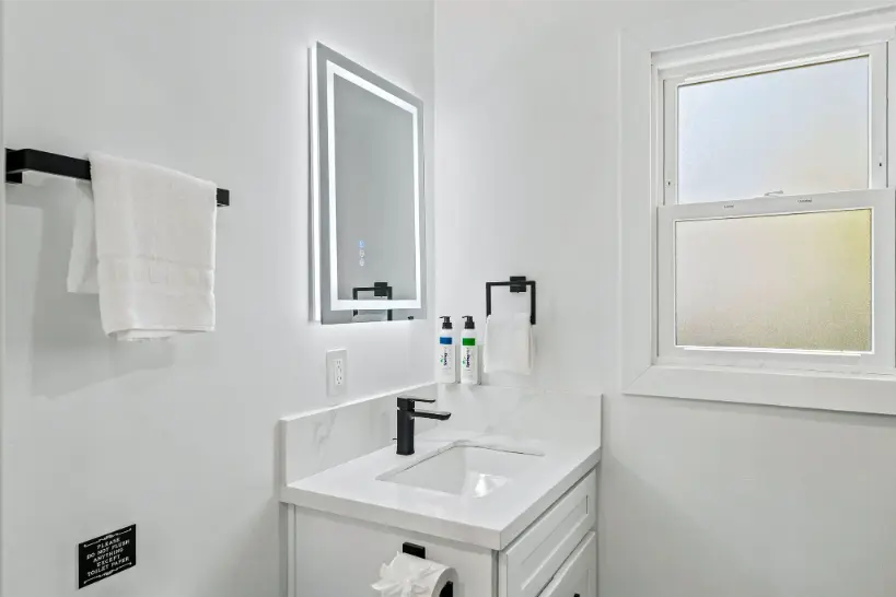Contemporary bathroom sink with a backlit LED mirror.