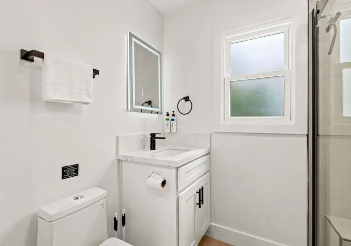 Bathroom vanity and toilet in Deluxe Queen suite.