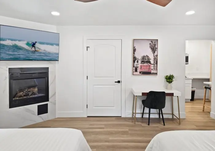 Fireplace, work desk, and TV setup in Deluxe Queen room.