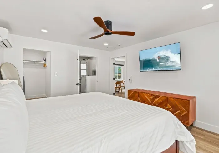 Penthouse bedroom featuring a bed, ceiling fan, and TV.