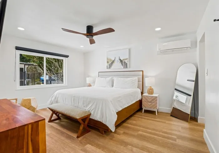 Penthouse bedroom with king bed and full-length mirror.