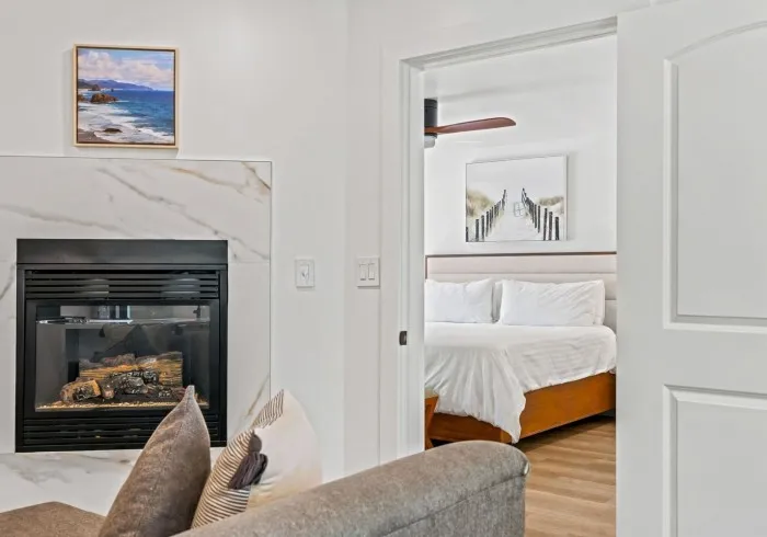 Penthouse living room fireplace with view into the bedroom.