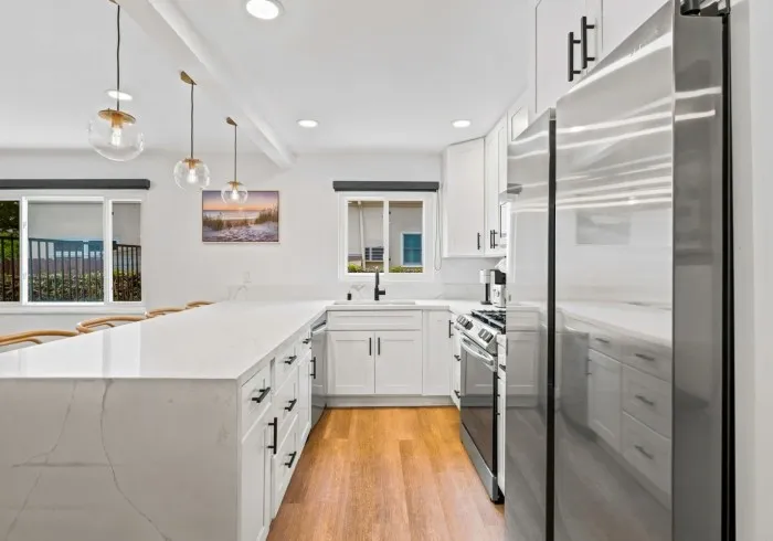Modern Penthouse kitchen with white cabinets and island.
