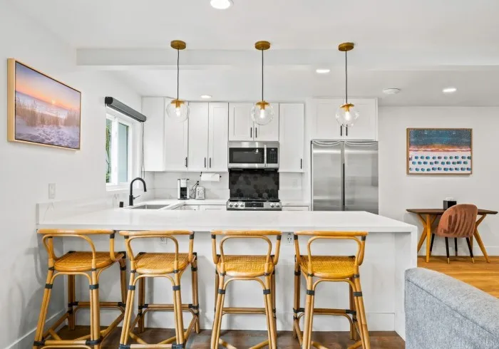 Penthouse kitchen island with stool seating and stainless steel appliances.