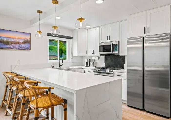 Penthouse kitchen showing island, counters, and refrigerator.