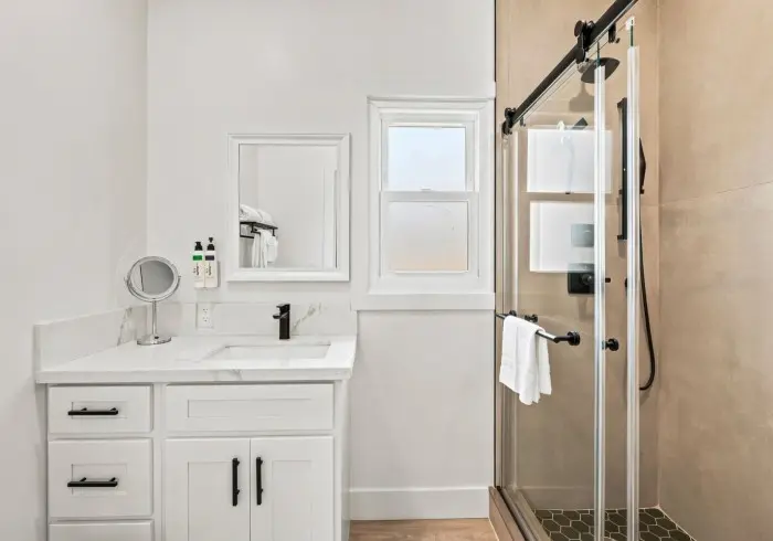 Bathroom vanity next to glass shower in Penthouse plus Studio.