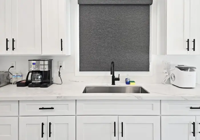 Kitchen sink and white cabinets in Penthouse plus Studio.