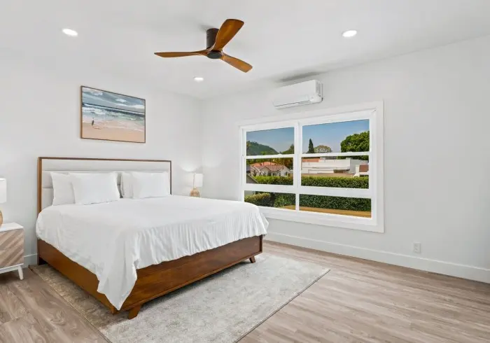 Bed with wall artwork and window in Penthouse plus Studio.