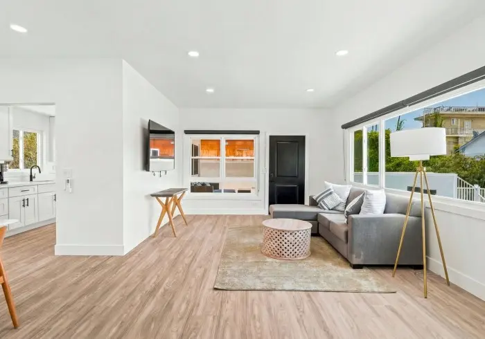 Living room with sectional sofa and windows in Penthouse plus Studio.